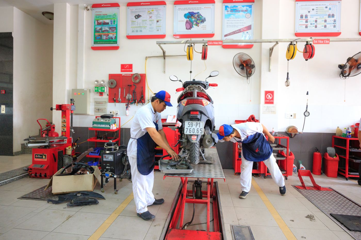 Two mechanics servicing a motorcycle