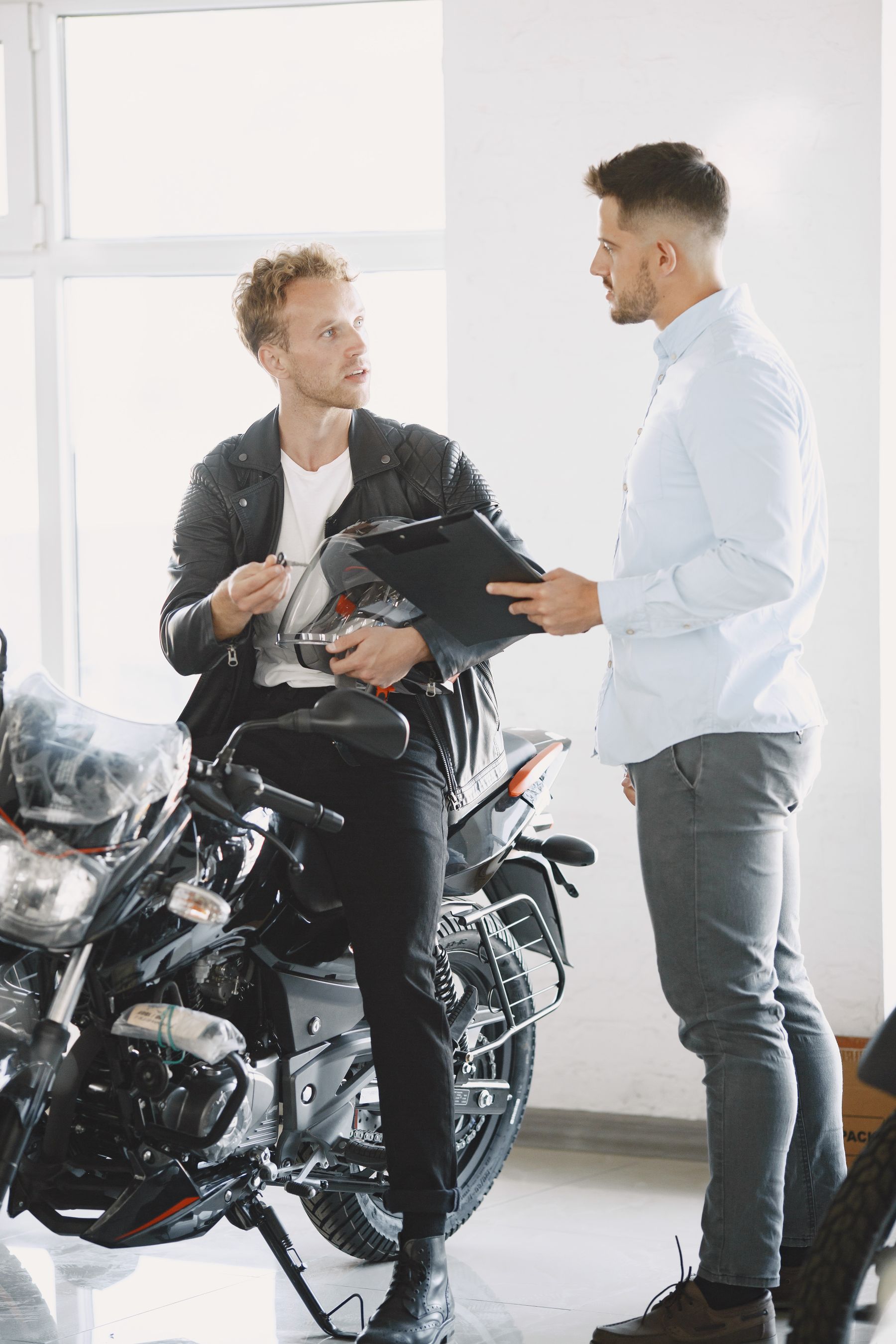 Two people discussing a motorcycle in a dealership